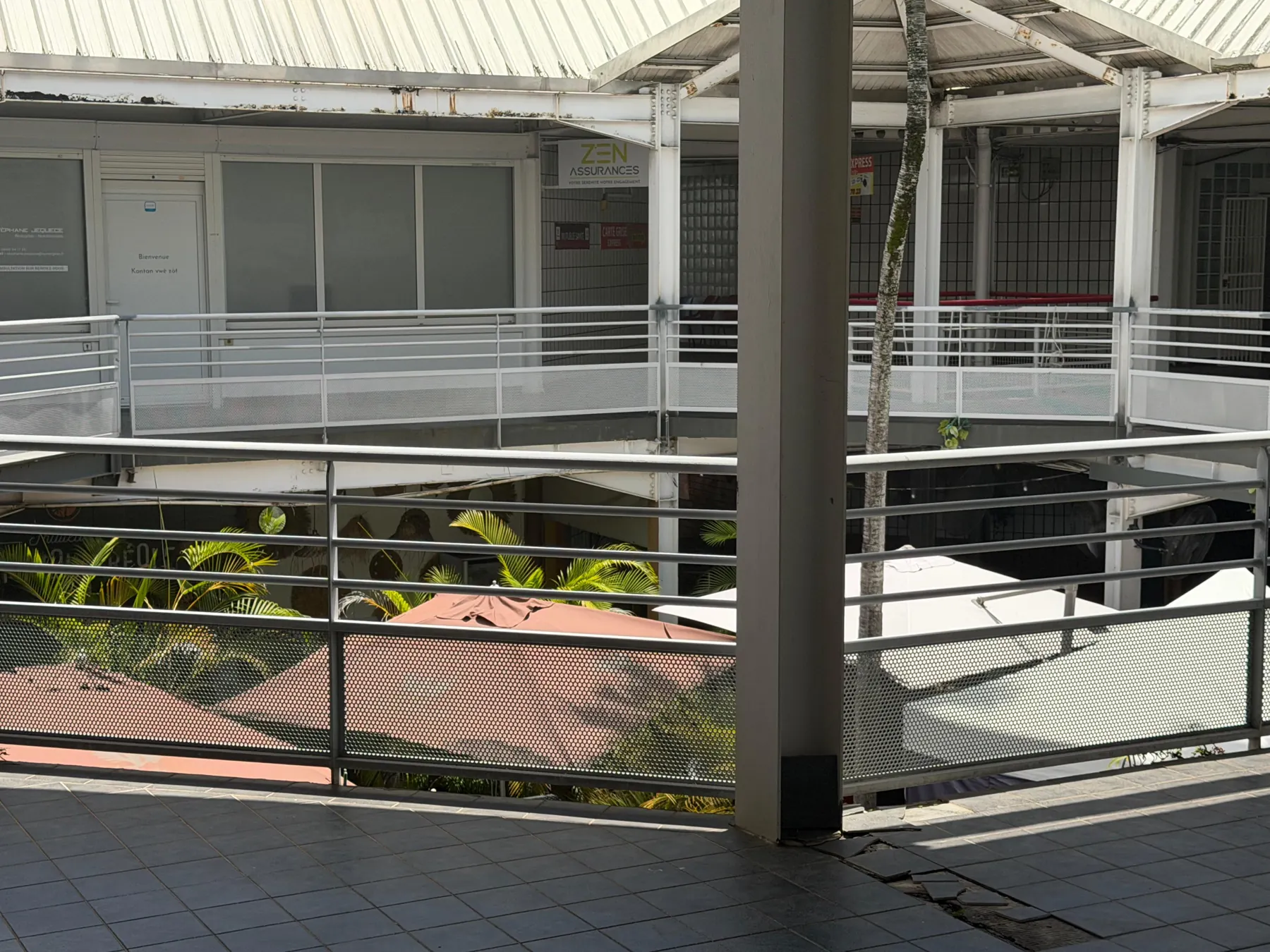 Le patio planté de palmiers vu depuis la coursive qui mène au cabinet