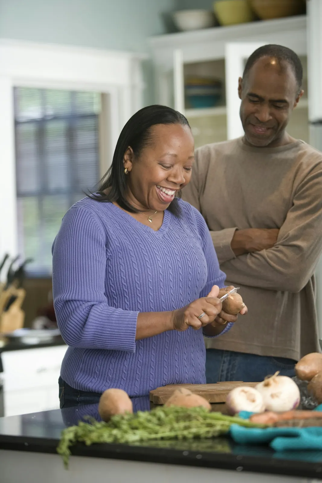 Femme souriante qui prépare le repas dans sa cuisine